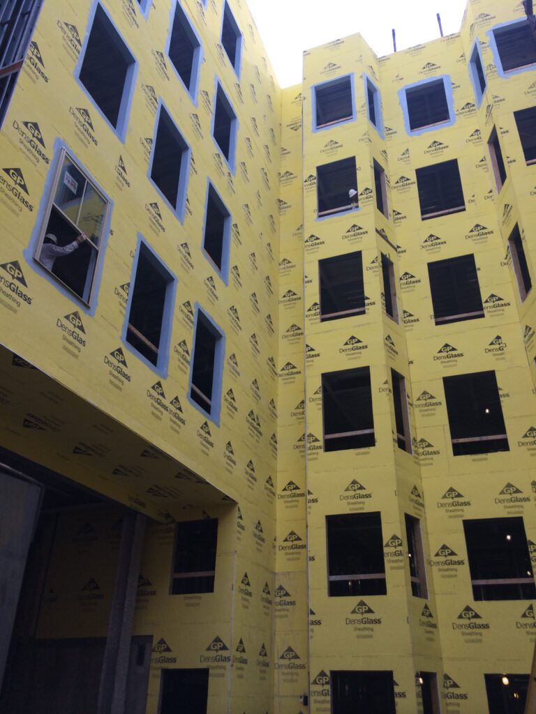 Protective yellow GP DensGlass covers on the exterior of the Morris and Clark Hotel